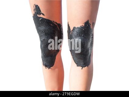 Women's legs with knees smeared with therapeutic mud, isolated on white background with clipping path. Stock Photo