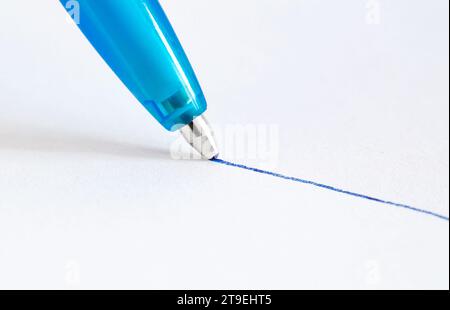 Ballpoint pen, drawing line in blue ink on white paper, close-up view Stock Photo