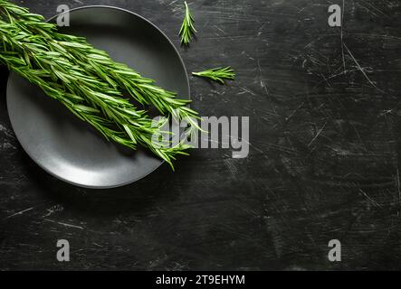 Rosemary fresh grass on dark plate. Top view dark background, with space to copy text. Stock Photo