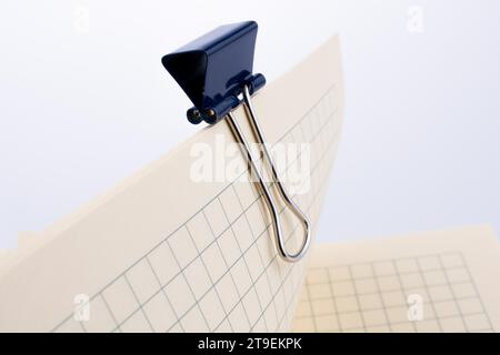 Colored paper clip on a checked notebook page Stock Photo