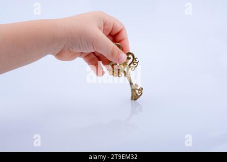 Child hand holding a retro styled decorative key Stock Photo