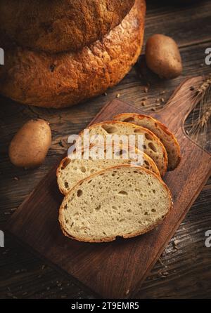 Freshly baked bread in rustic setting. Sliced sourdough bread Stock Photo