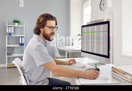 Focused businessman working on spreadsheet on computer in office. Stock Photo