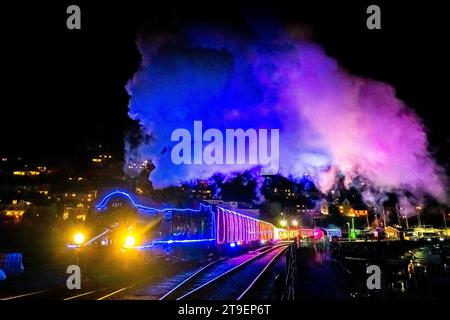 Kingswear, Devon, UK.  24th November 2023.   The Christmas Train of Lights on the Dartmouth Steam Railway which runs between 24th November to 30th December 2023, pulls out of Kingswear station in Devon on its way to Paignton.  The carriages and steam locomotives on the festive service are lit inside and out with coloured lights.  Picture Credit: Graham Hunt/Alamy Live News Stock Photo