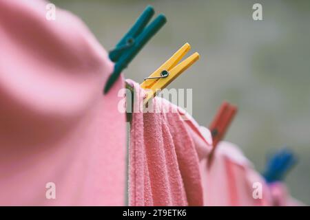 pink bedding is dried on a rope with plastic clothespins. Stock Photo