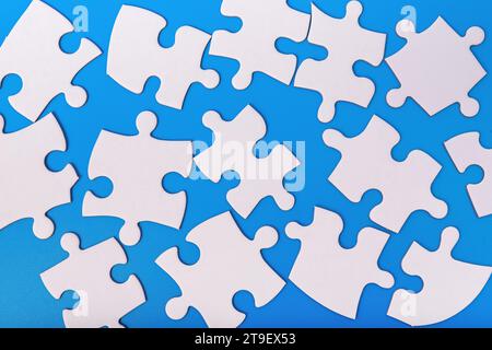 Scattered puzzle pieces, jigsaw elements in chaos, mess Stock Photo