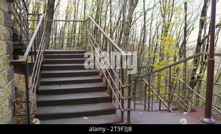 an empty staircase with metal railings and several flights in an autumn park, a fragment of a large city staircase in a deserted park without people Stock Photo