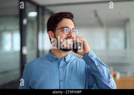 Young busy latin businessman talking on the phone in office. Stock Photo