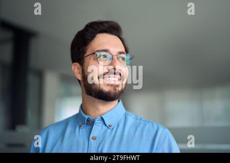Happy young latin business man leader wearing glasses looking away. Stock Photo