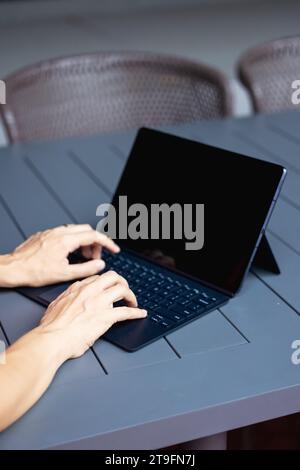 Close up of a womans hands on keyboard of lap top in the dark room, people working at home, modern black notebook. Internet, work, technology concept. Stock Photo