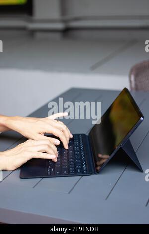 Close up of a womans hands on keyboard of lap top in the dark room, people working at home, modern black notebook. Internet, work, technology concept. Stock Photo