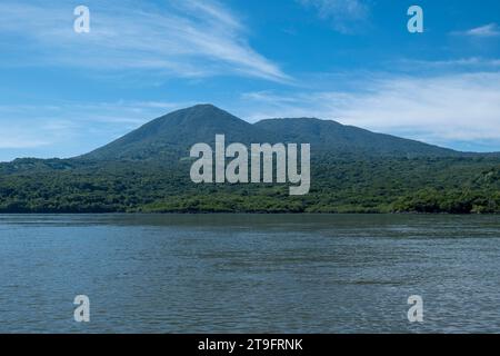 Coastline Seen From Afar with Huge Volcanic Mountain with Lush Vegetation Forest in Front of a Calm Ocean near La Union, El Salvador Stock Photo