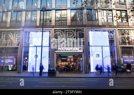 LONDON- NOVEMBER 23, 2023: Footasylum shoe shop and motion blurred shoppers on Oxford Street, landmark retail destination Stock Photo