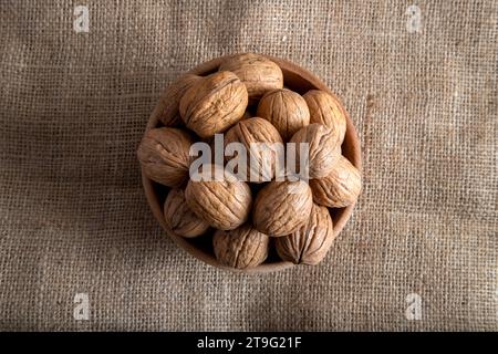 Bowl full of shelled walnuts on burlap sack,top view Stock Photo