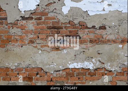 Damaged brick wall facade of very old house. Abstract background photo. Ideal for placement of text. Stock Photo