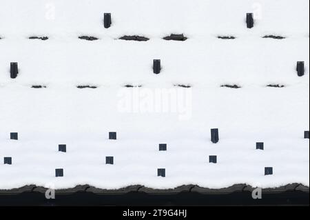 Abstract photography of black roof covered by first snow. Freezing weather. Stock Photo