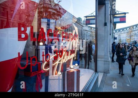 LONDON- NOVEMBER 23, 2023: Shoppers on Regent Street with Black Friday signage in the window, a landmark shopping destination in London's west end Stock Photo