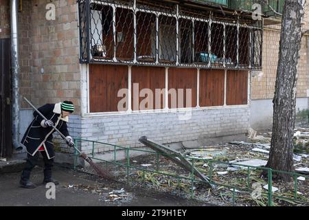 Kyiv, Ukraine. 25th Nov, 2023. A local resident cleans up debris following a drone attack on apartment building in Kyiv. (Photo by Oleksii Chumachenko/SOPA Images/Sipa USA) Credit: Sipa USA/Alamy Live News Stock Photo