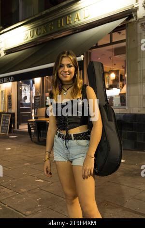 Female singer and guitarist outside the Buck's Head pub in Camden Town, London which hosts a weekly open mic session Stock Photo