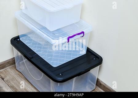 Empty plastic storage boxes in stack. Boxes with lids of different sizes. Plastic transparent boxes for moving items. Stock Photo