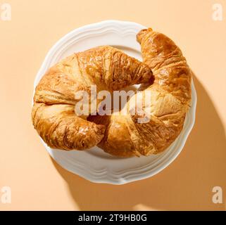 freshly baked croissants on white plate, top view Stock Photo
