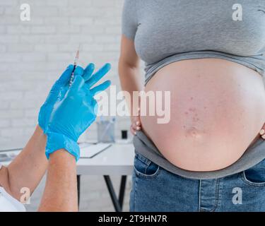 Doctor gives an injection in the stomach of a pregnant woman Stock ...