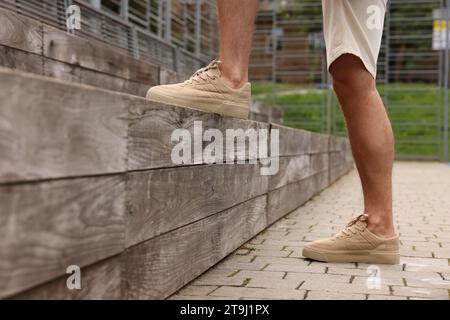 Man wearing pair of stylish sneakers outdoors, closeup Stock Photo