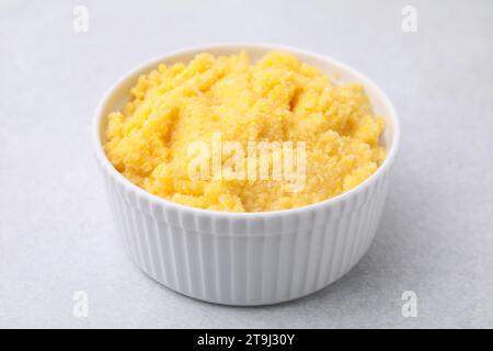 Tasty cornmeal in bowl on light gray table, closeup Stock Photo