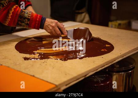 Chocolatier spreading chocolate as a demonstration Stock Photo