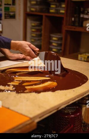 Chocolatier spreading chocolate as a demonstration Stock Photo