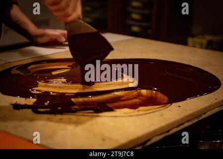 Chocolatier spreading chocolate as a demonstration Stock Photo