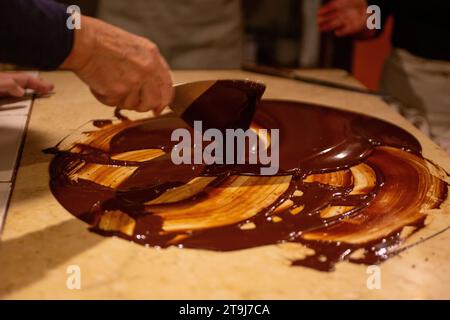 Chocolatier spreading chocolate as a demonstration Stock Photo