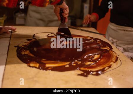 Chocolatier spreading chocolate as a demonstration Stock Photo