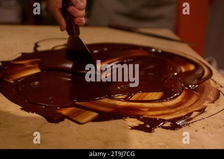 Chocolatier spreading chocolate as a demonstration Stock Photo