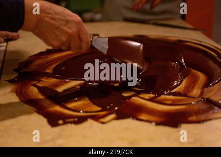 Chocolatier spreading chocolate as a demonstration Stock Photo