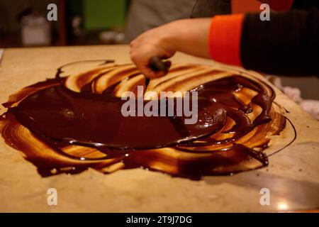 Chocolatier spreading chocolate as a demonstration Stock Photo