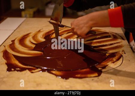 Chocolatier spreading chocolate as a demonstration Stock Photo