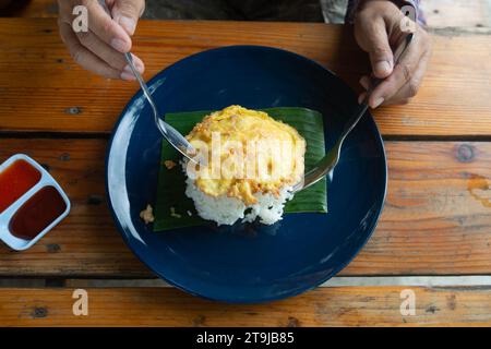 Top view photo of someone is eating thai style omelet rice that so simple like fast food in Thailand. Stock Photo