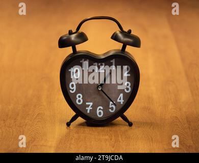 Retro alarm clock on wooden table. Stock Photo