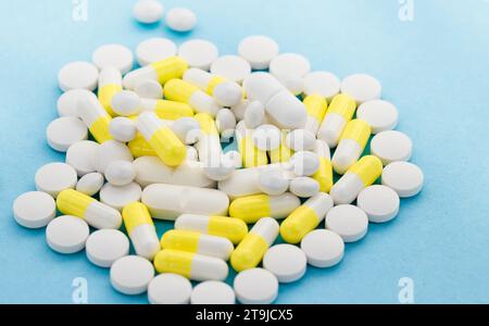 White and yellow pills and capsules were scattered on the table Stock Photo