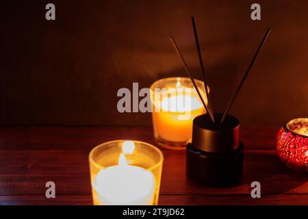 Serene Aromatherapy Setting: Reed Diffuser and Burning Candles on Wooden Table Stock Photo
