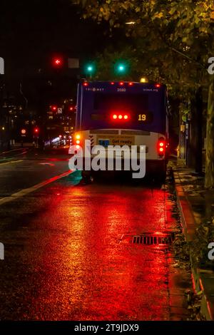 Reflections of bus taillights on a  rainy night on the streets of Portland, Oregon, USA Stock Photo