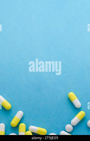 Assorted white and yellow pills on blue table. Medical, pharmacy and healthcare concept. Copy space. Empty place for text or logo. Stock Photo