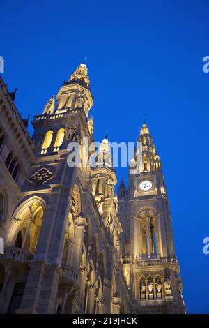 The Rathause building decorated with golden night lights whose front yard is used as a Christmas Market (Wiener Christkindlmarkt) at night in winter Stock Photo