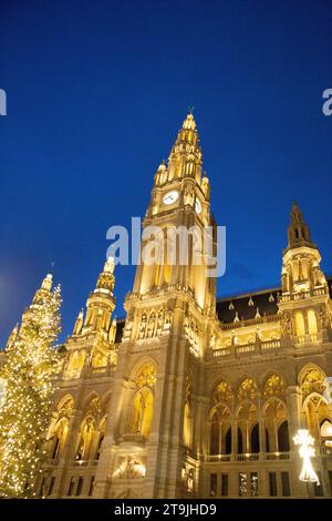 The Rathause building decorated with golden night lights whose front yard is used as a Christmas Market (Wiener Christkindlmarkt) at night in winter Stock Photo