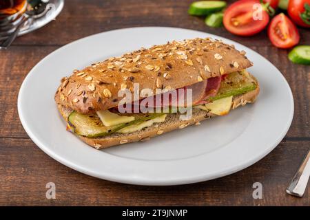Vegetable and ham sandwich with tea on wooden table Stock Photo