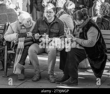 People eating on a bench Stock Photo