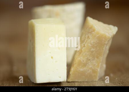 a piece of parmesan cheese next to a piece of pecorino romano Stock Photo