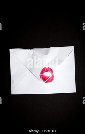 Crumpled White Envelope with Red Lipstick Kiss on Black Stock Photo