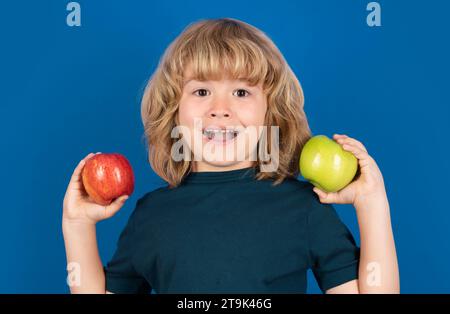 Excited child hold apple on isolated background. Stock Photo